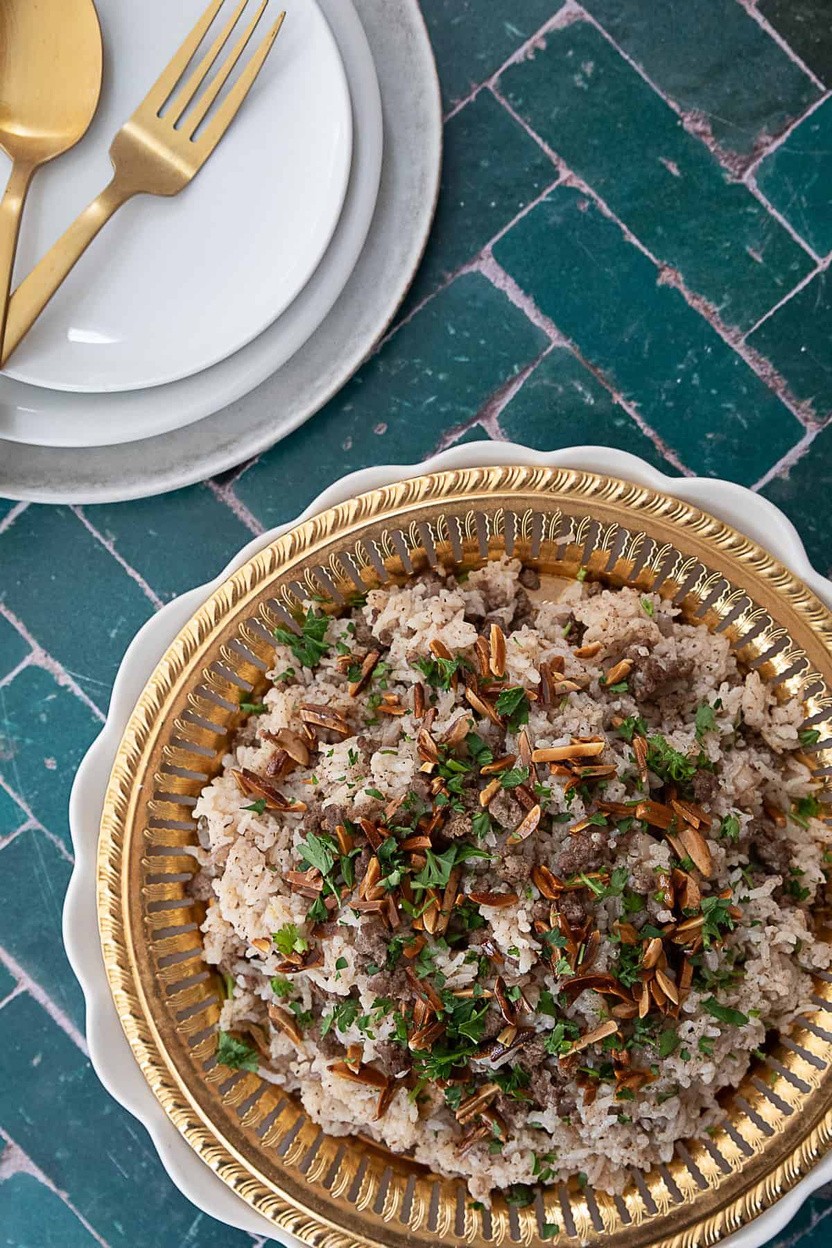 A close-up shot of Hashweh rice, showcasing the tender grains of rice mixed with seasoned ground beef and spices, garnished with fresh parsley and toasted nuts.