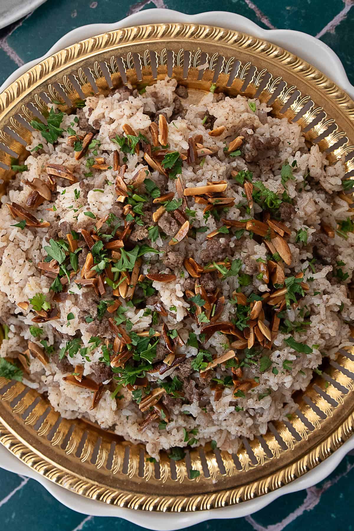 Hashweh rice served in a decorative bowl, sprinkled with slivered almonds and fresh parsley, adding a pop of color and texture.