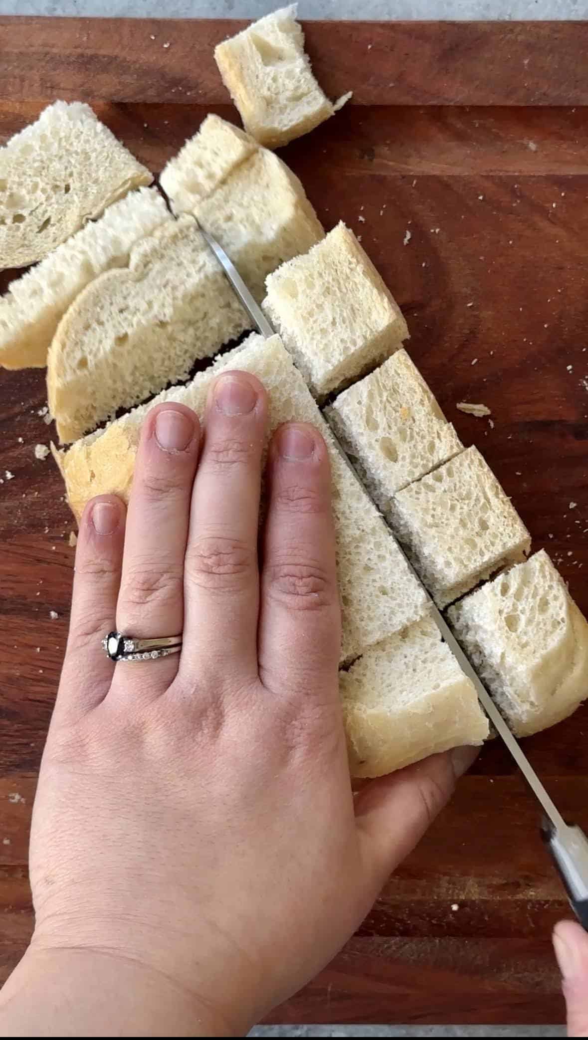 Homemade Croutons Recipe slicing sourdough bread into cubes for croutons