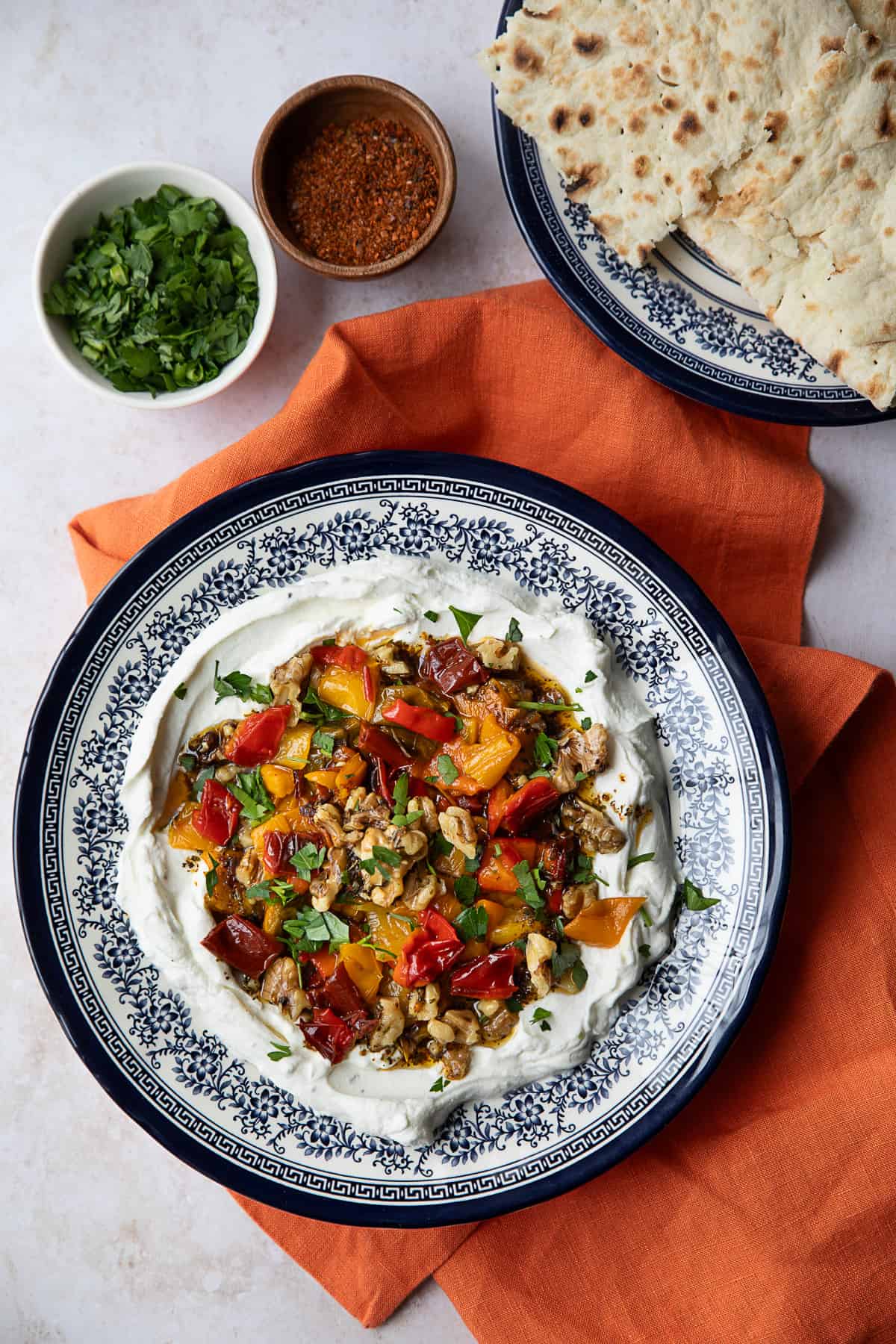 Labneh and roasted pepper dip in a blue bowl. 