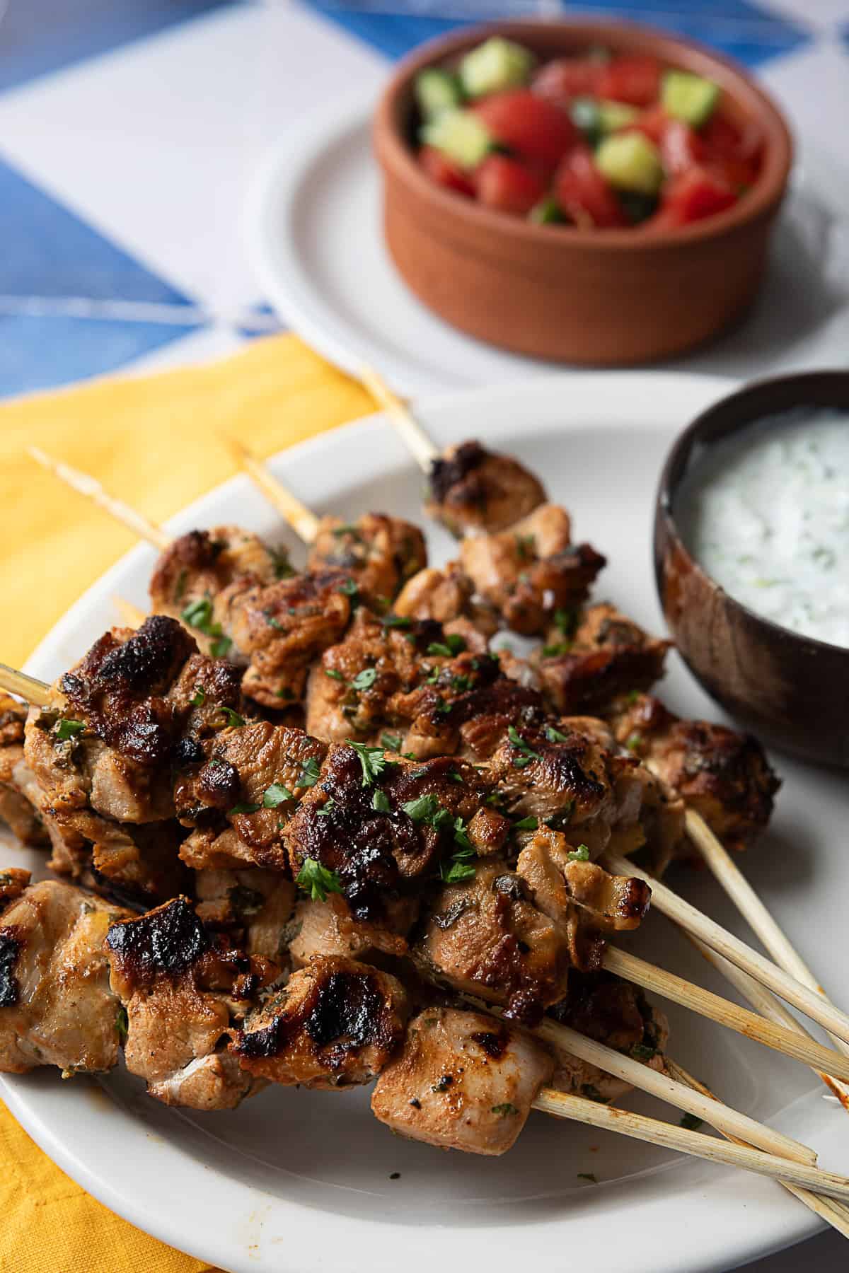 Grilled Mediterranean chicken skewers served with tzatziki sauce and cucumber tomato salad