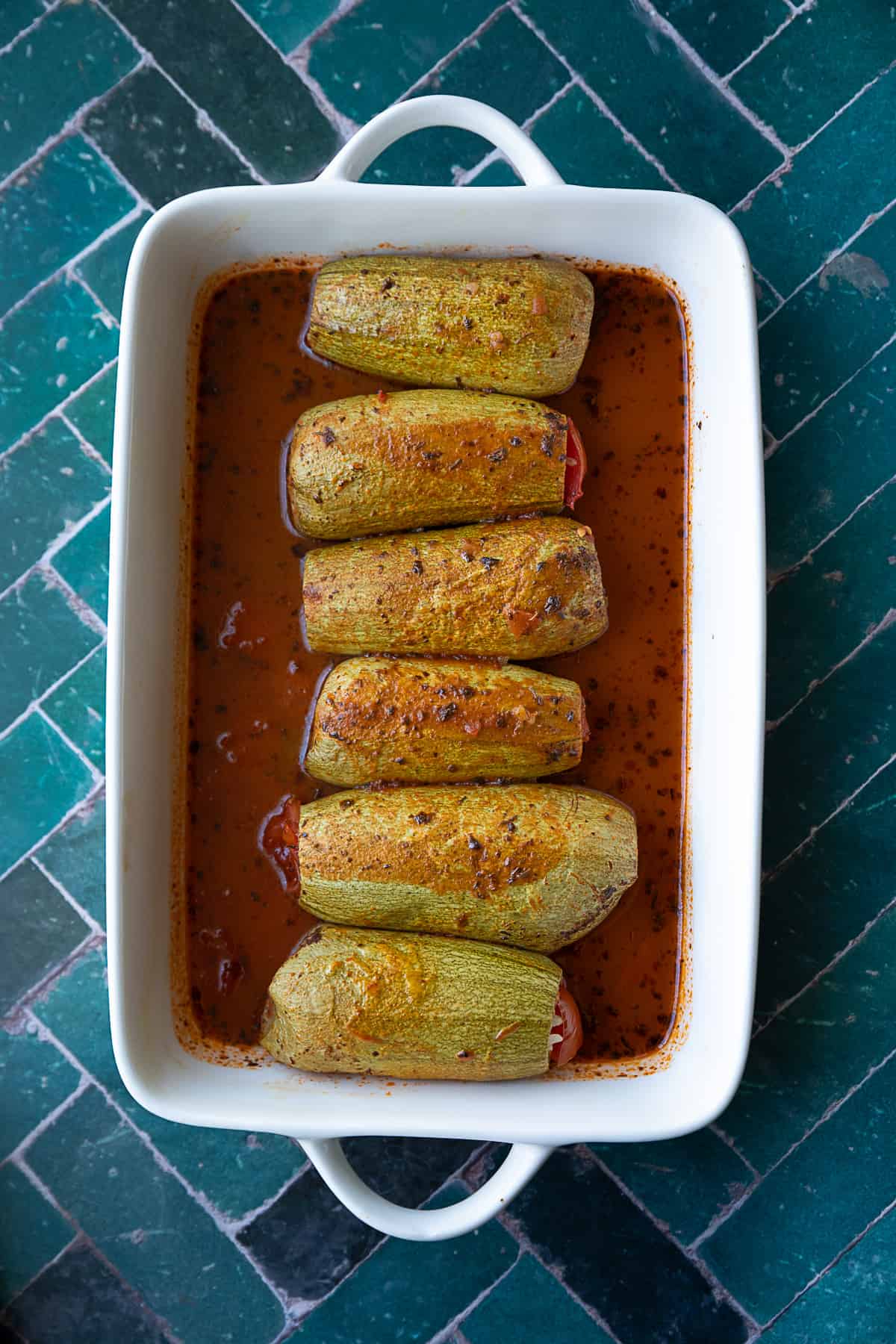 Turkish stuffed zucchini served in sauce in a classic white dish