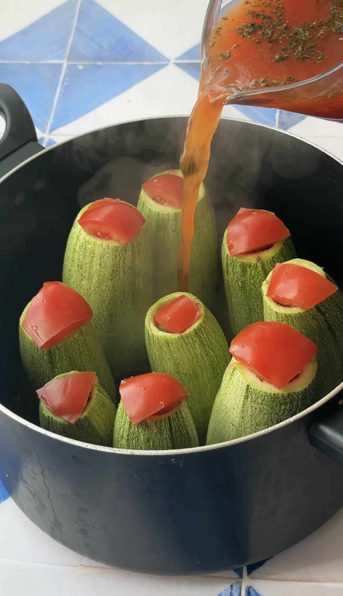 add stuffed zucchini to a pot and pour sauce over it