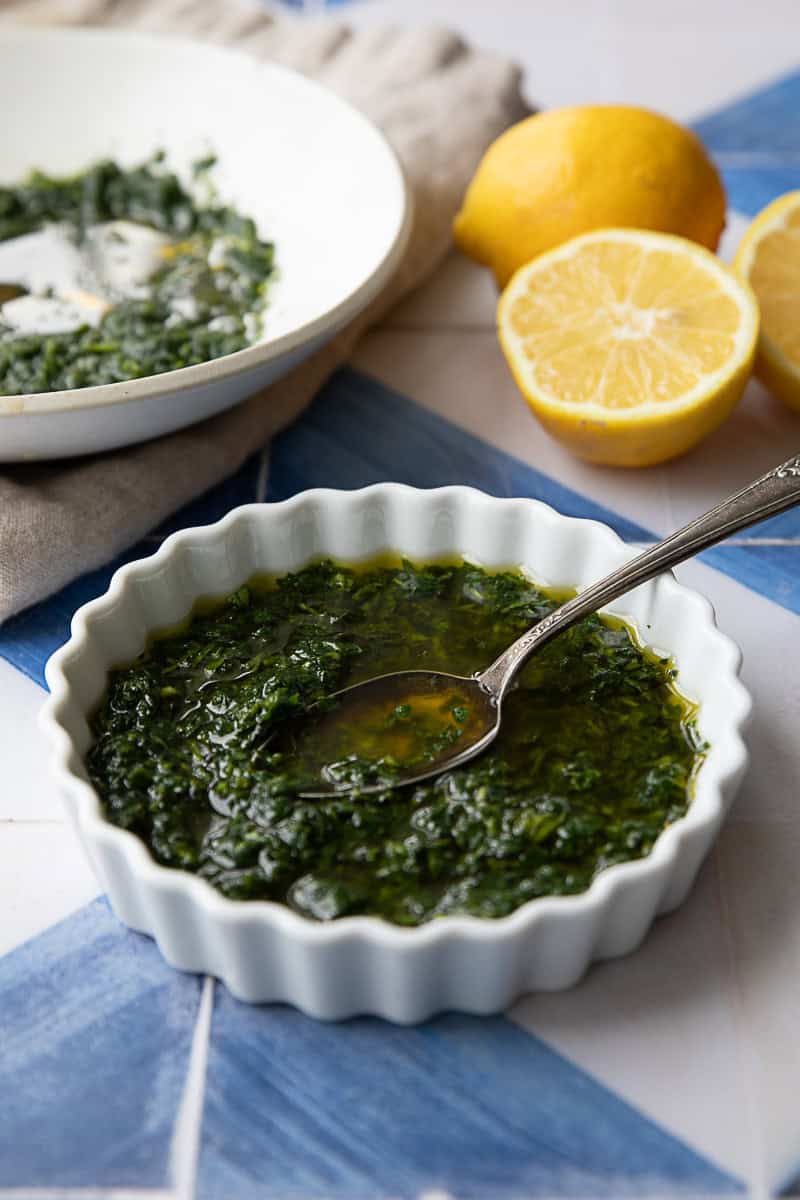 Gremolata (Lemon-Parsley Italian Condiment) gremolata served in a white bowl with lemon slices in background