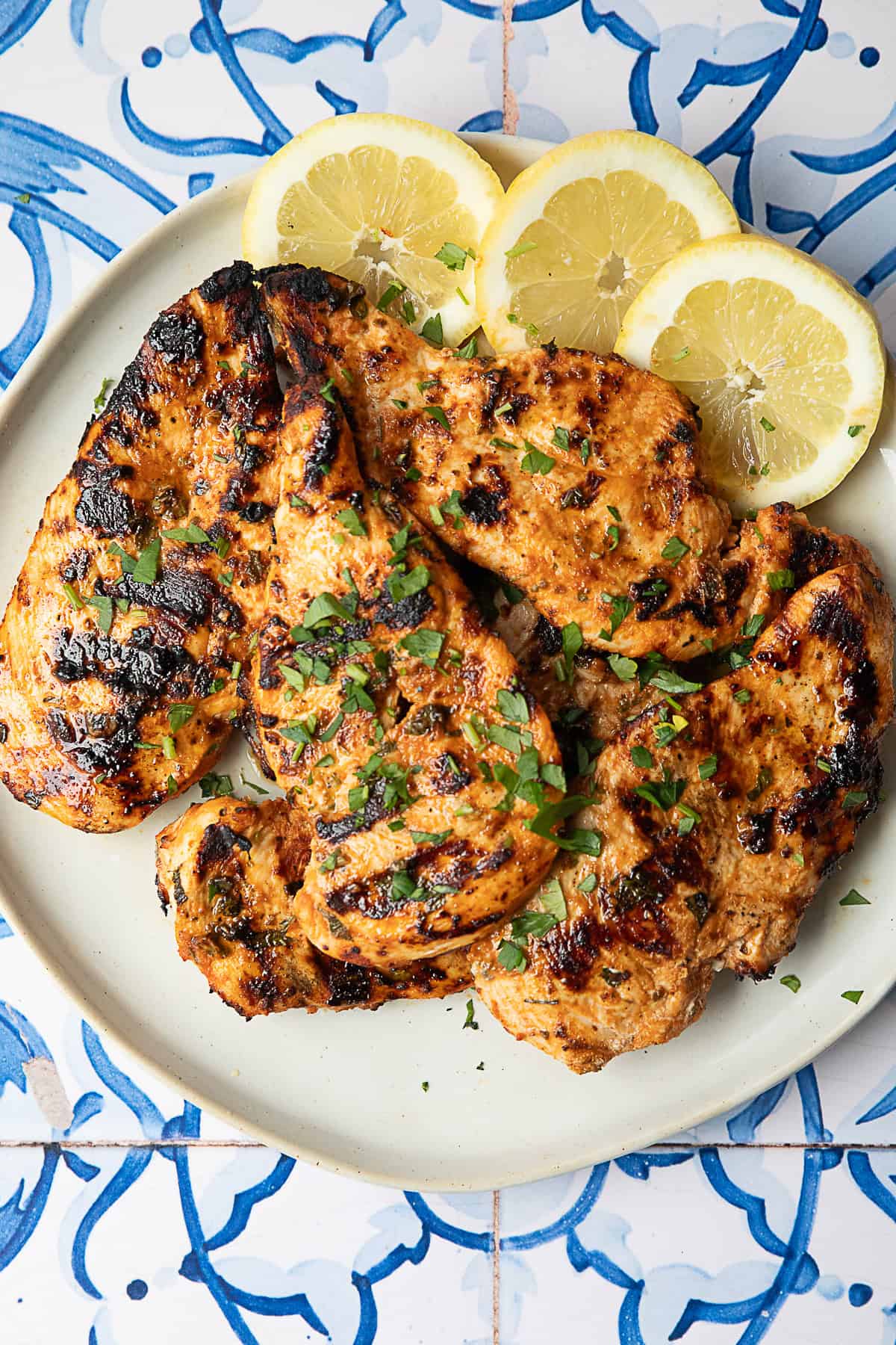 Best Middle Eastern Inspired Grilled Chicken Breast Middle Eastern-inspired grilled chicken breast served on a white platter with sliced lemon rounds