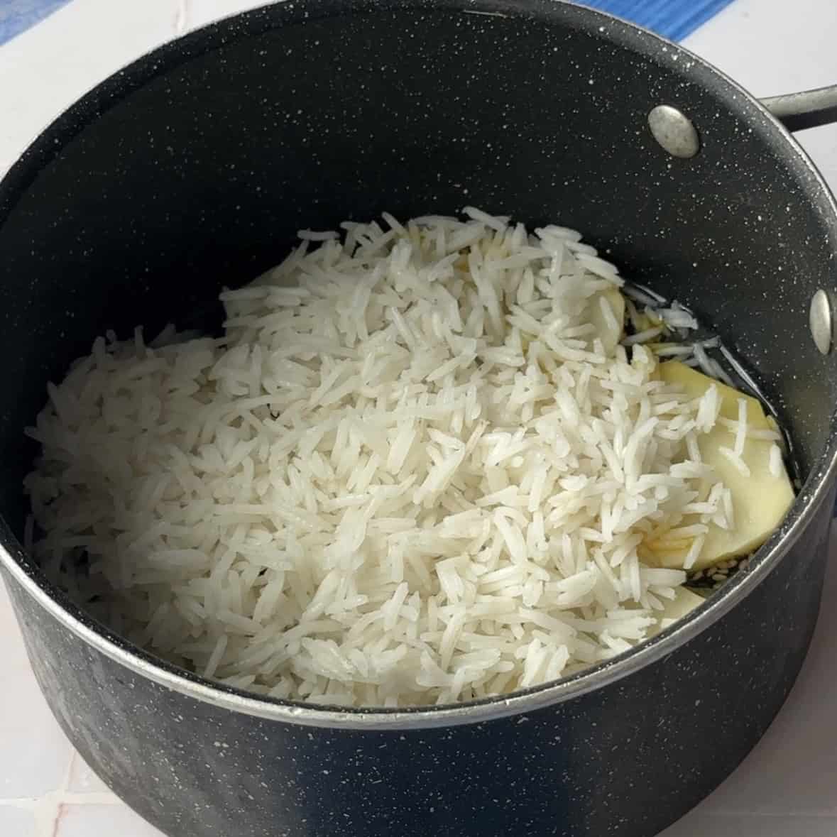 boiled rice placed on top of the potato slices in a mount shape