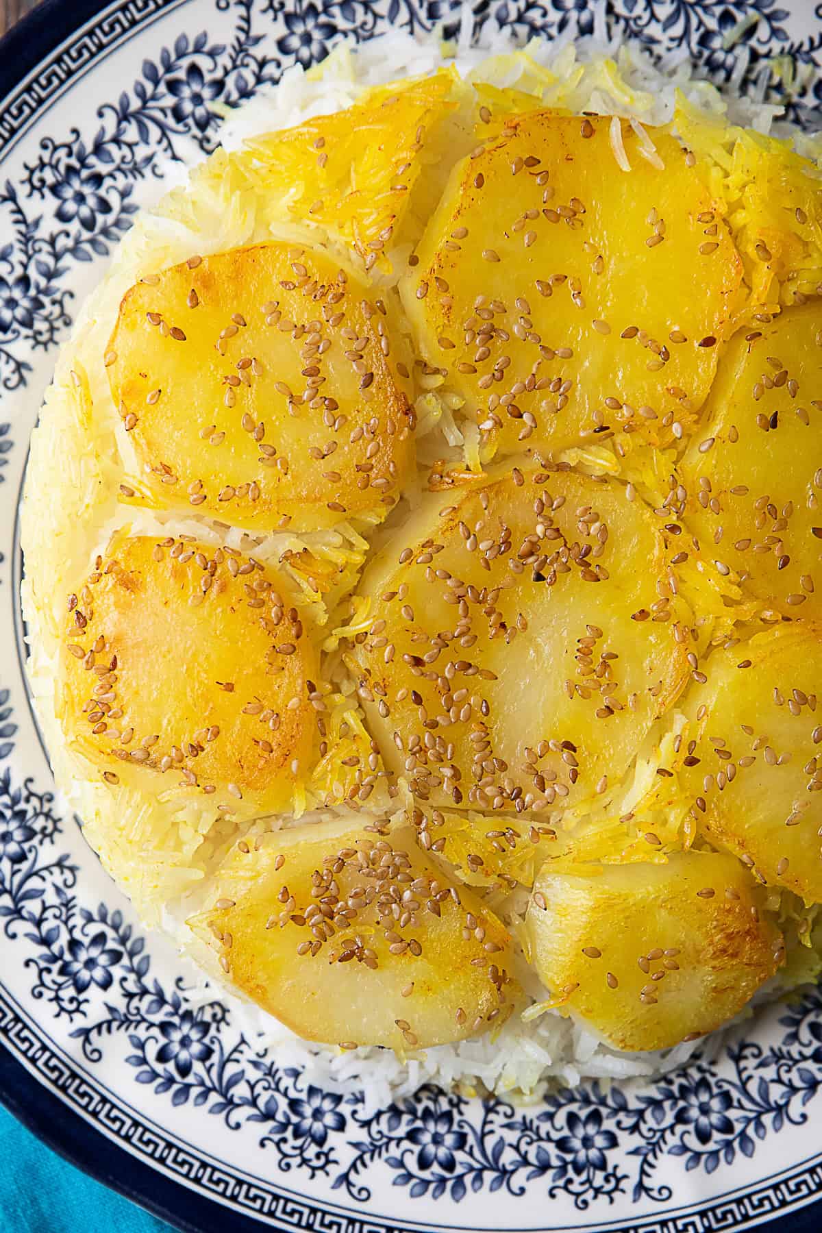 Persian potato tahdig: A delicious dish featuring crispy golden potatoes atop fragrant saffron-infused rice, served in a traditional Iranian pot, symbolizing the rich flavors of Persian cuisine.