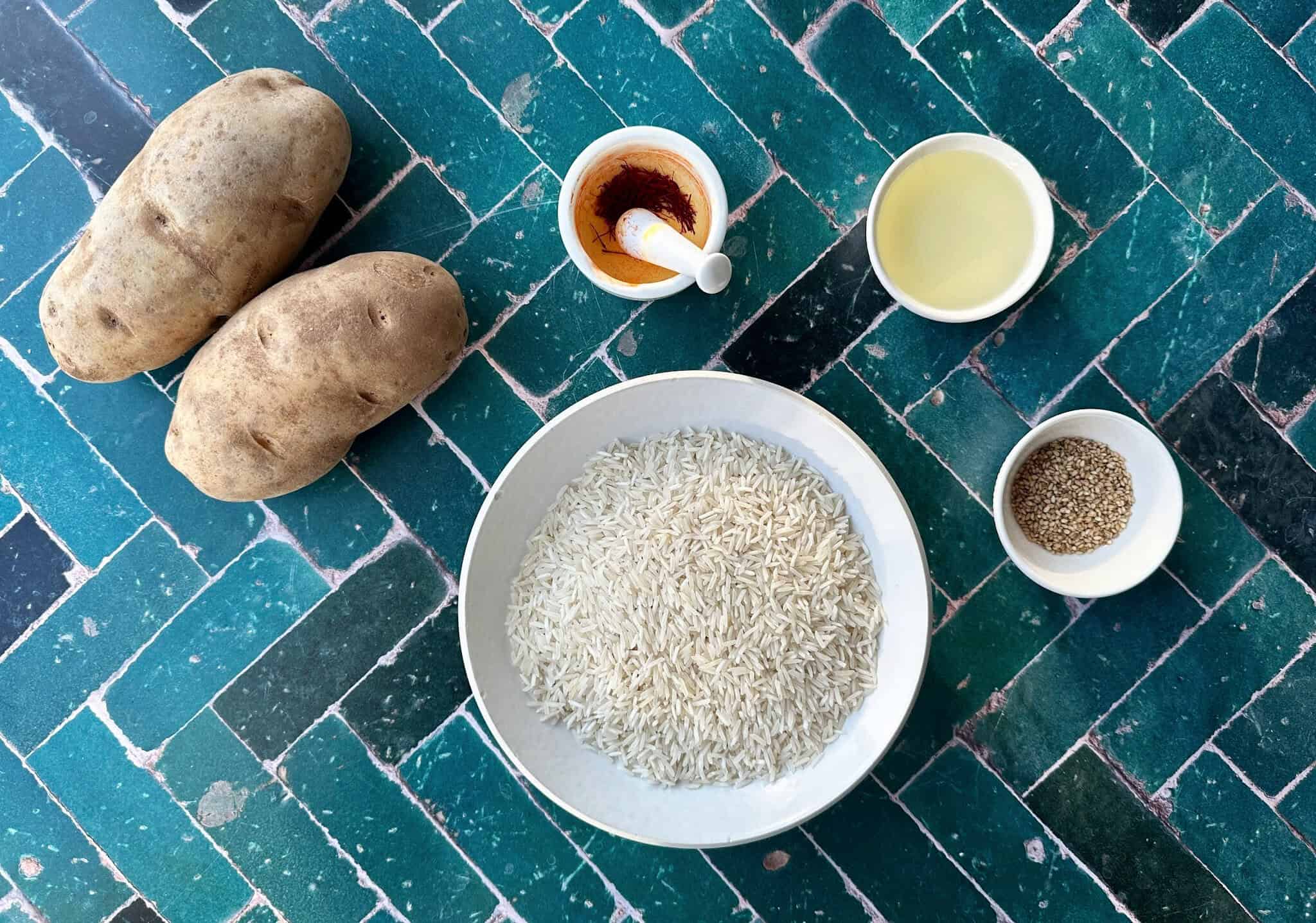 Ingredients to make potato tahdig are potatoes, rice, saffron oil and sesame seeds. 