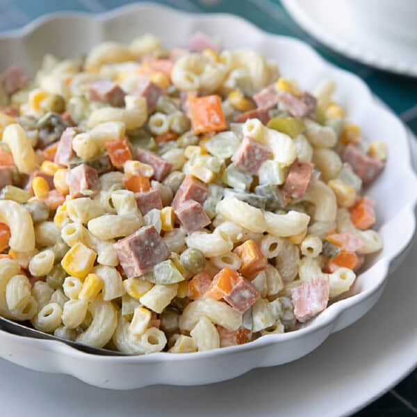 Persian style macaroni salad served in white serving bowl placed on a white serving platter