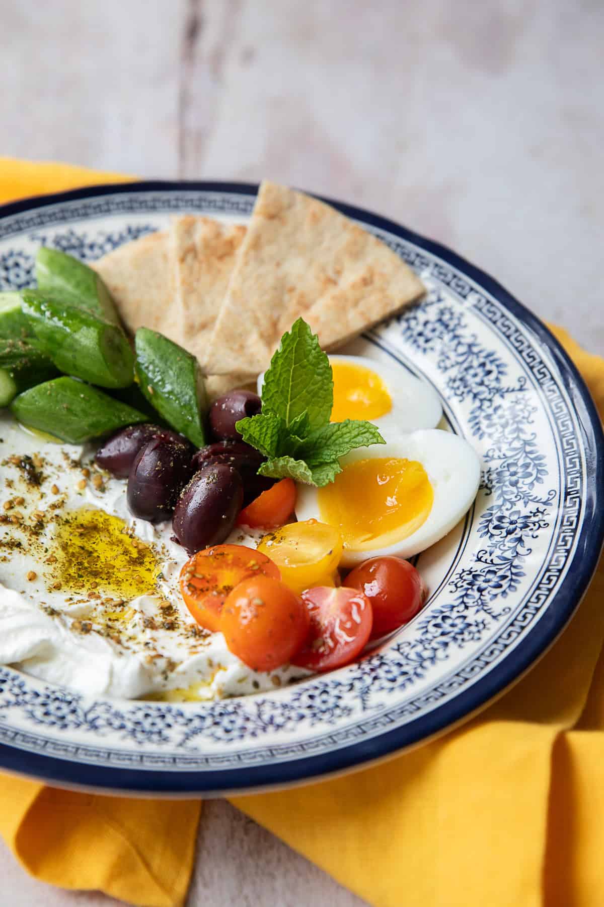 Front shot of a bowl with labneh and vegetables.