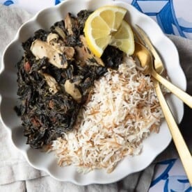 molokhia w roz (rice) served in a white bowl with lemon wedges