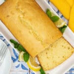 olive oil lemon loaf cooked to perfection and served on a white platter with a soft and fluffy slice on display