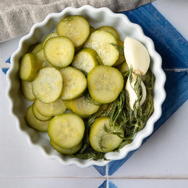 sliced pickled cucumbers served in a white bowl