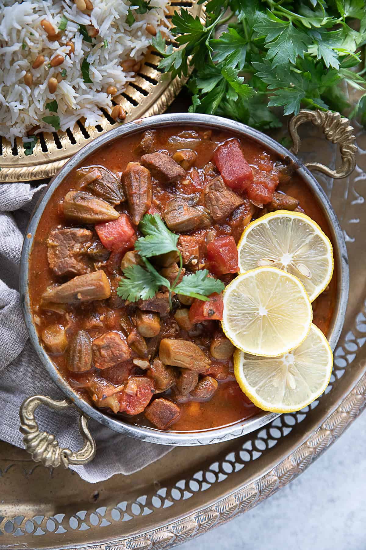 A top view of bowl of bamya okra stew served hot topped with lemon wedges