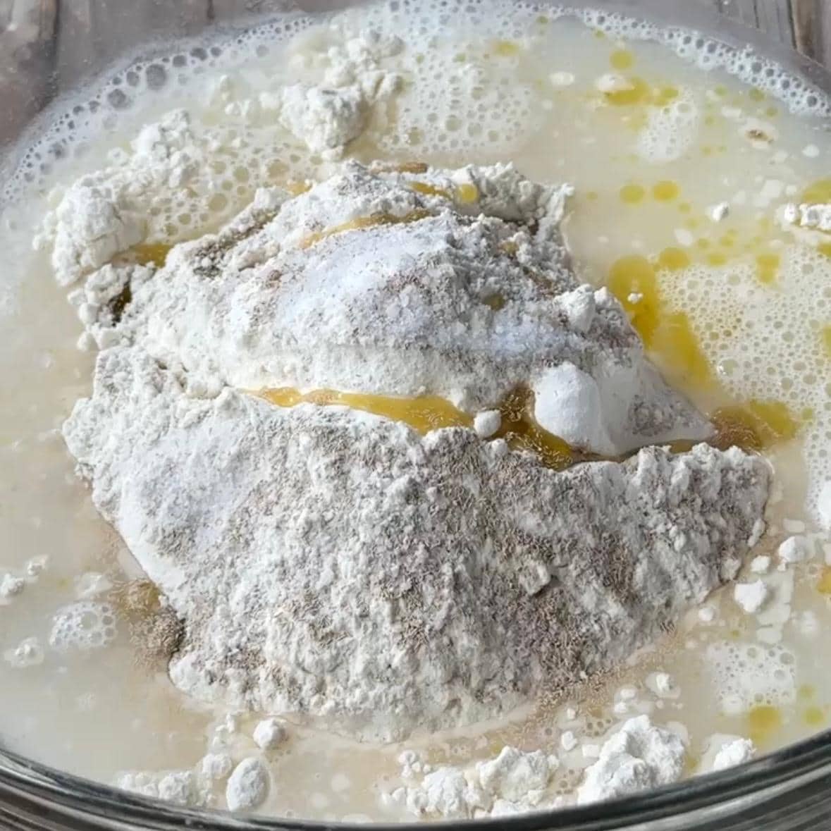 a large bowl that contains fatayer dough ingredients before mixing and kneading