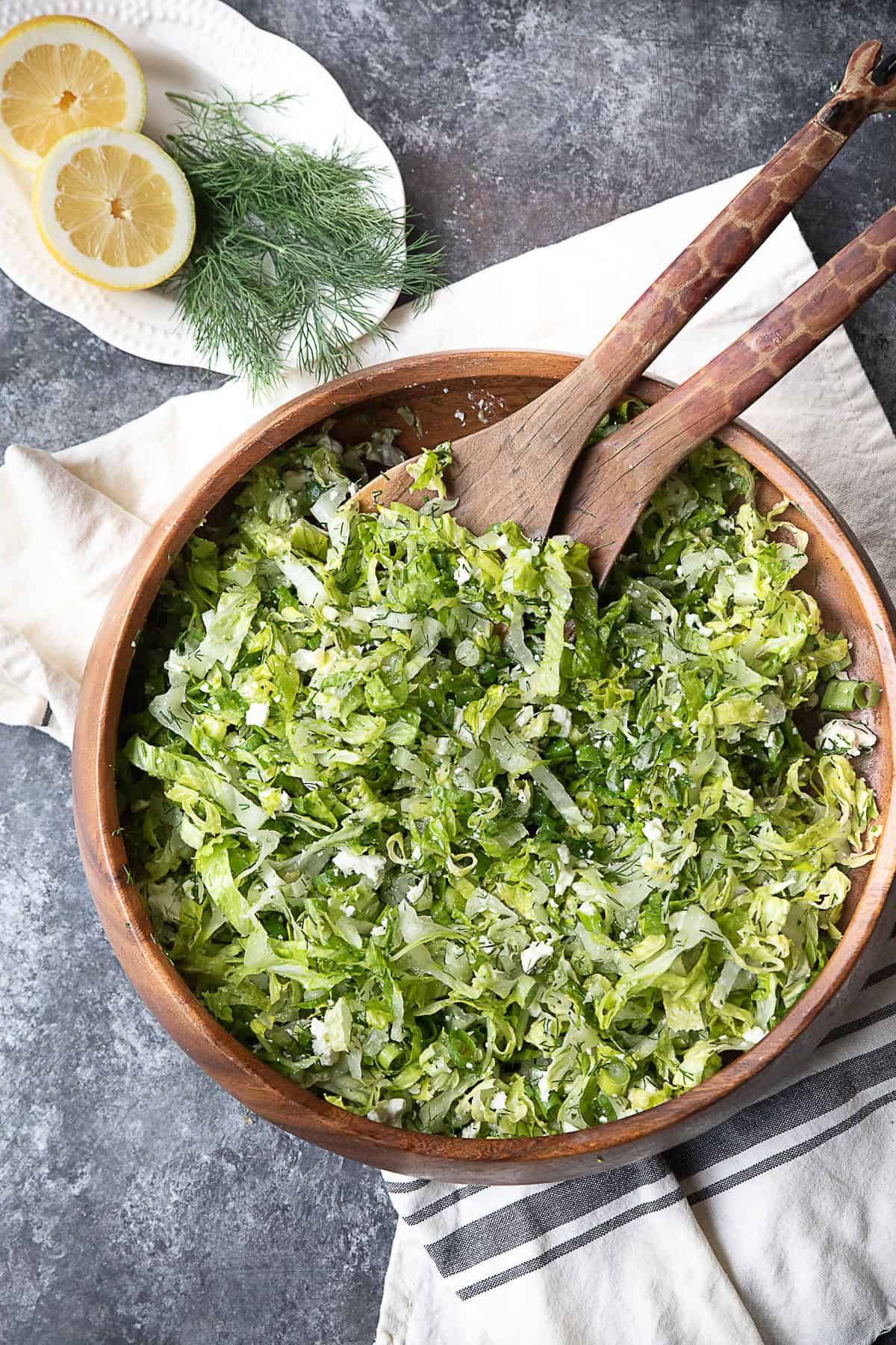 Greek Lettuce Salad A wooden bowl packed with fresh Maroulosalata salad.