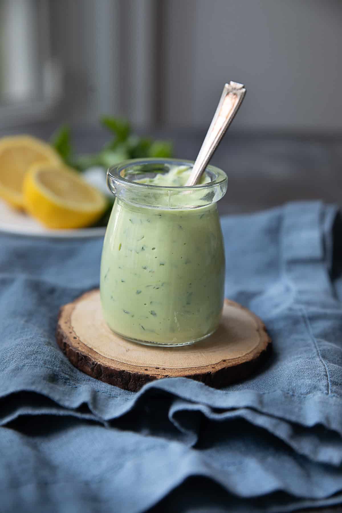 a glass jar of creamy smoothy Greek yogurt avocado dressing