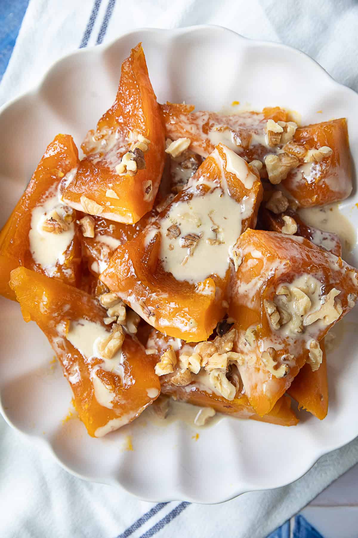 Kabak Tatlisi Tarifi Plate of Turkish pumpkin dessert Kabak Tatlisi topped with tahini and chopped walnuts.