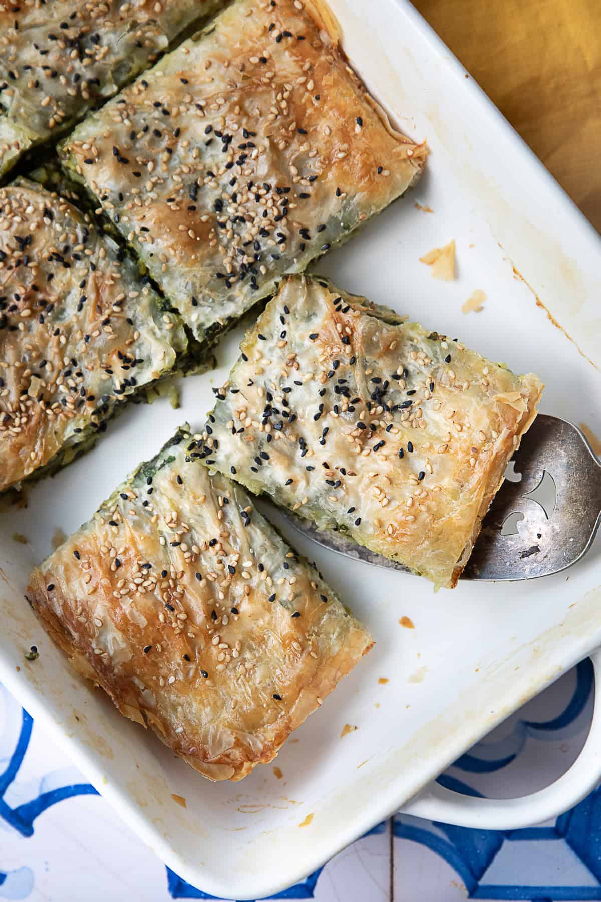 Spinach Feta Cheese Borek A detailed view of sliced spinach and feta borek pieces arranged in a pan.