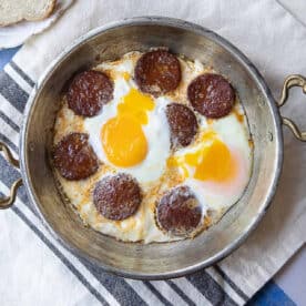 Sucuklu yumurta Turkish sausage and eggs in a pan.