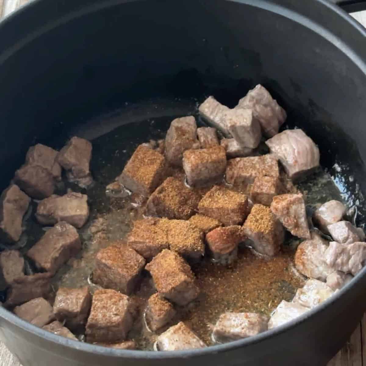 How to Make Bamya Searing the lamb cubes in a pot. The lamb cubes are garnished with seven spices.