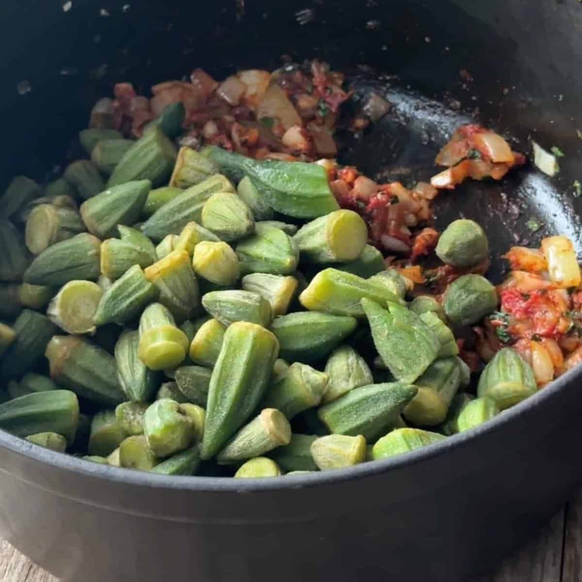 How to Make Okra Stew a pot with frozen okra, diced tomato, and sautéed garlic and onion