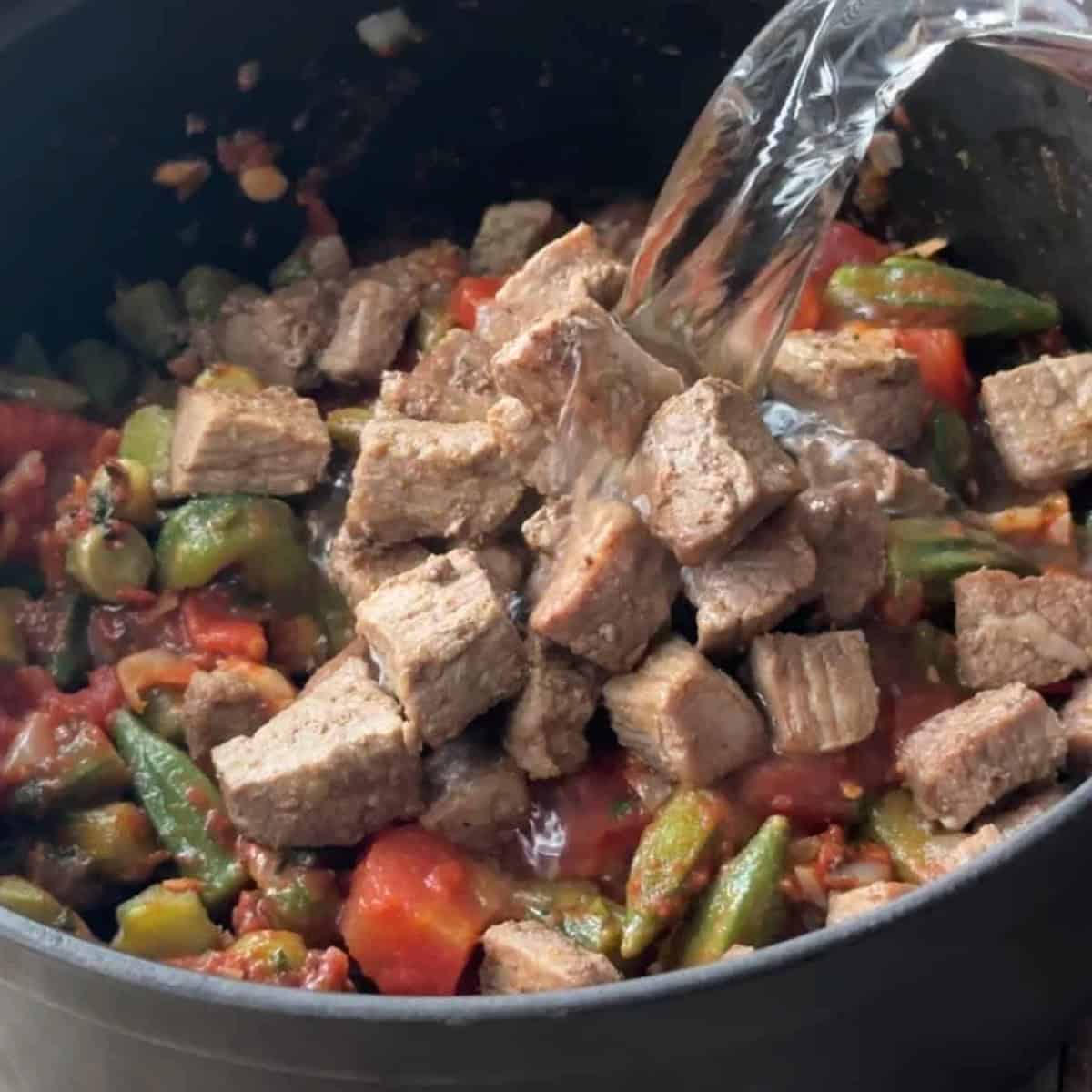 add the seared lamb to the pot over okra along with 4 cups of water