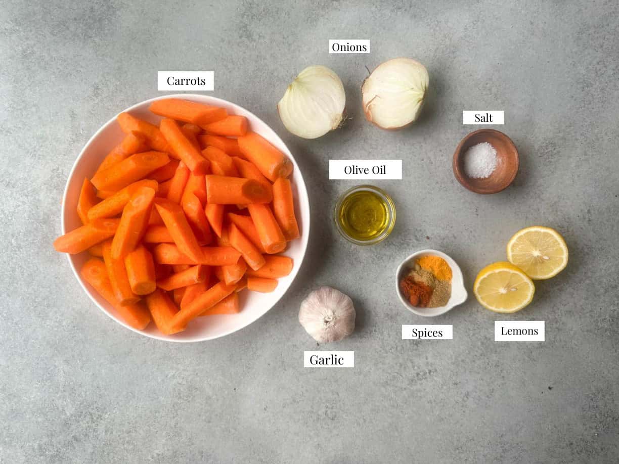 Roasted Carrot Soup Ingredients ingredients for roasted carrot soup including carrots, onions, olive oil, salt, spices, garlic, and lemons
