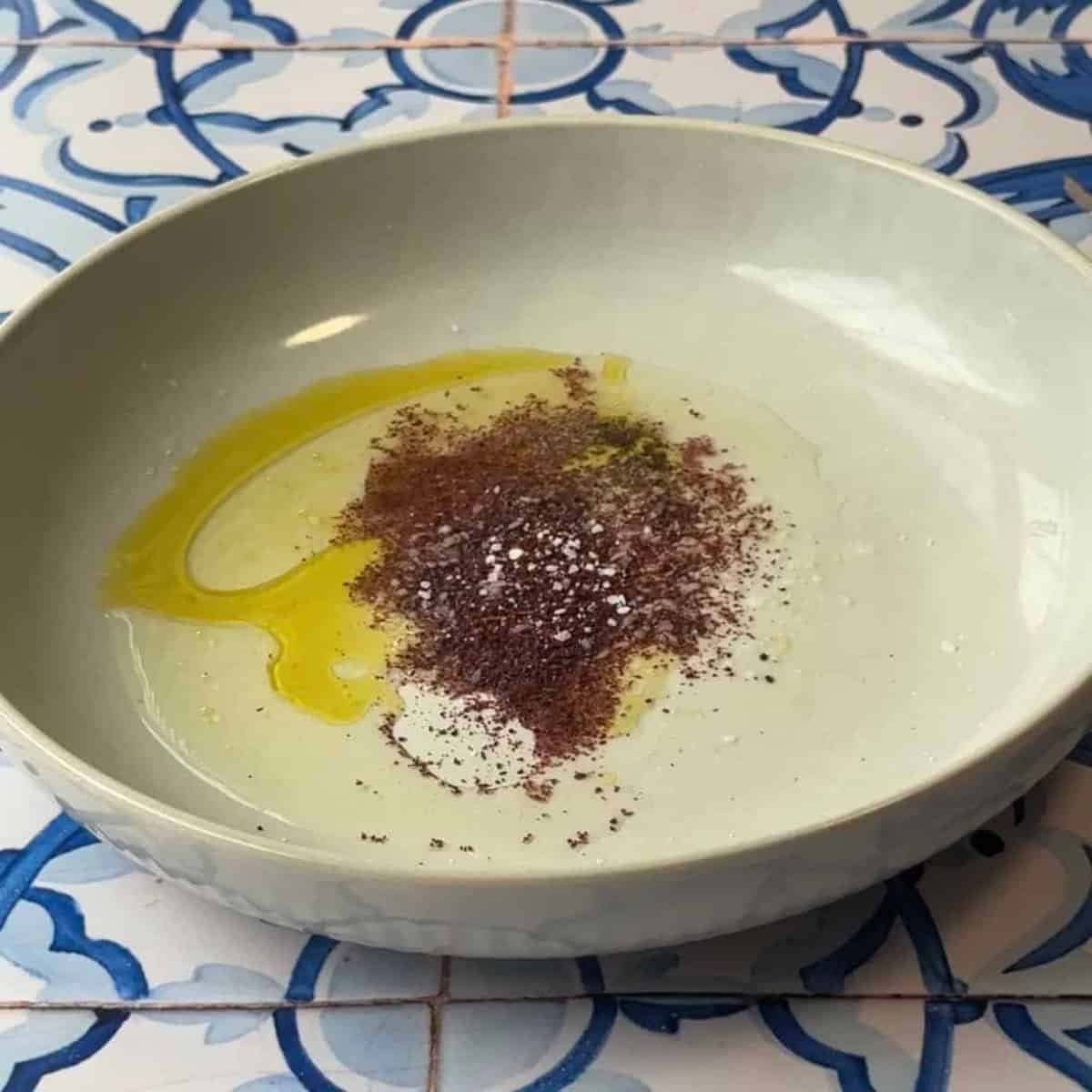 Mediterranean Chickpea Salad Dressing make dressing in bowl by mixing olive oil, lemon juice, sumac, salt, and pepper