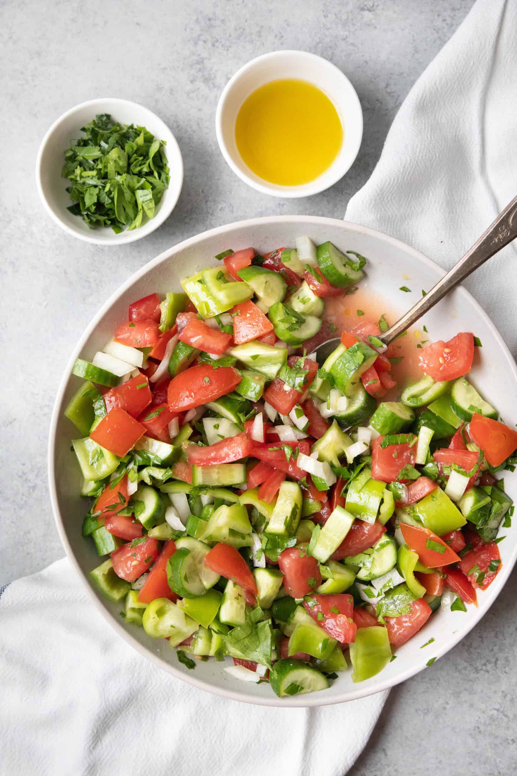 Authentic Çoban Salatası Çoban Salatası (Turkish Shepherd’s Salad) served in a white bowl with dressing and garnish on the side