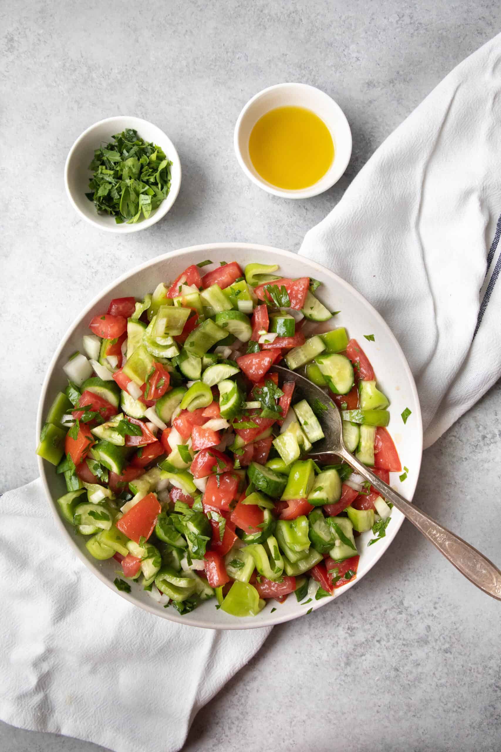How to Make Coban Salatasi Çoban Salatası (Turkish Shepherd’s Salad) served in a white bowl with dressing and garnish on the side
