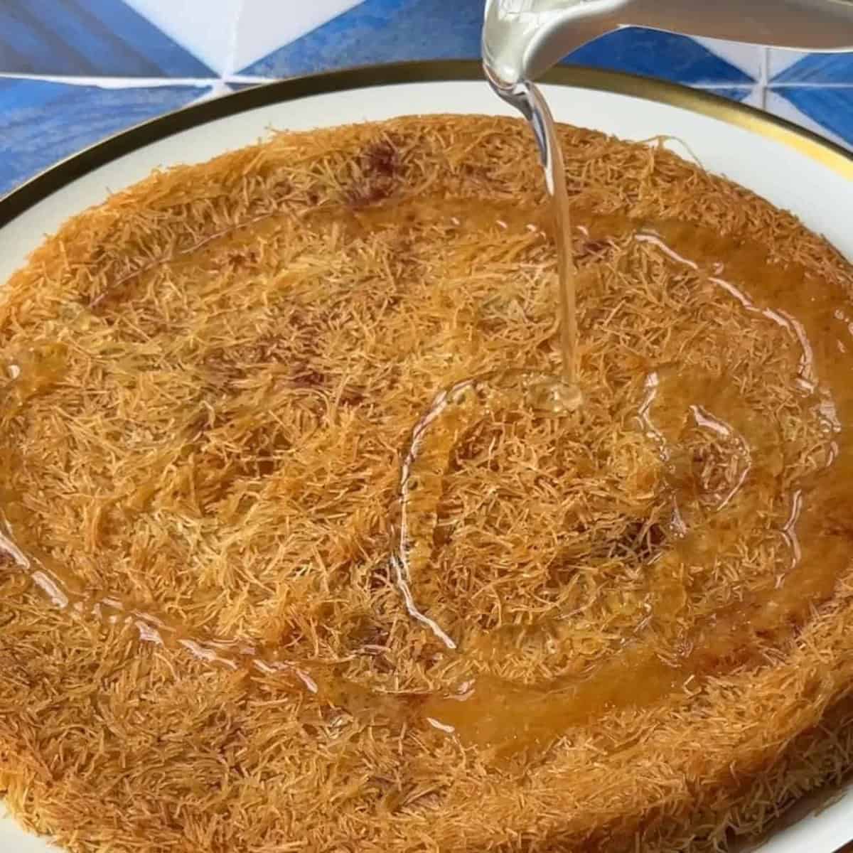 golden kunafa topped with rose petals and chopped pistachios