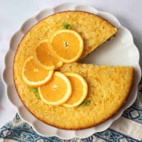 A plate of Greek orange cake known as portokalopita on a white background.