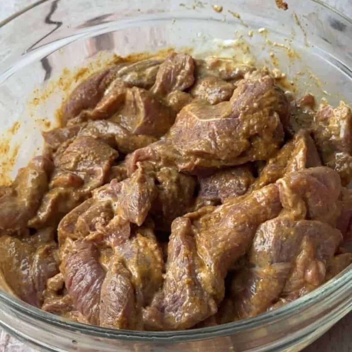 Easy Authentic Homemade Lamb Shawarma add lamb meat to a bowl and add spices and other ingredients to marinate