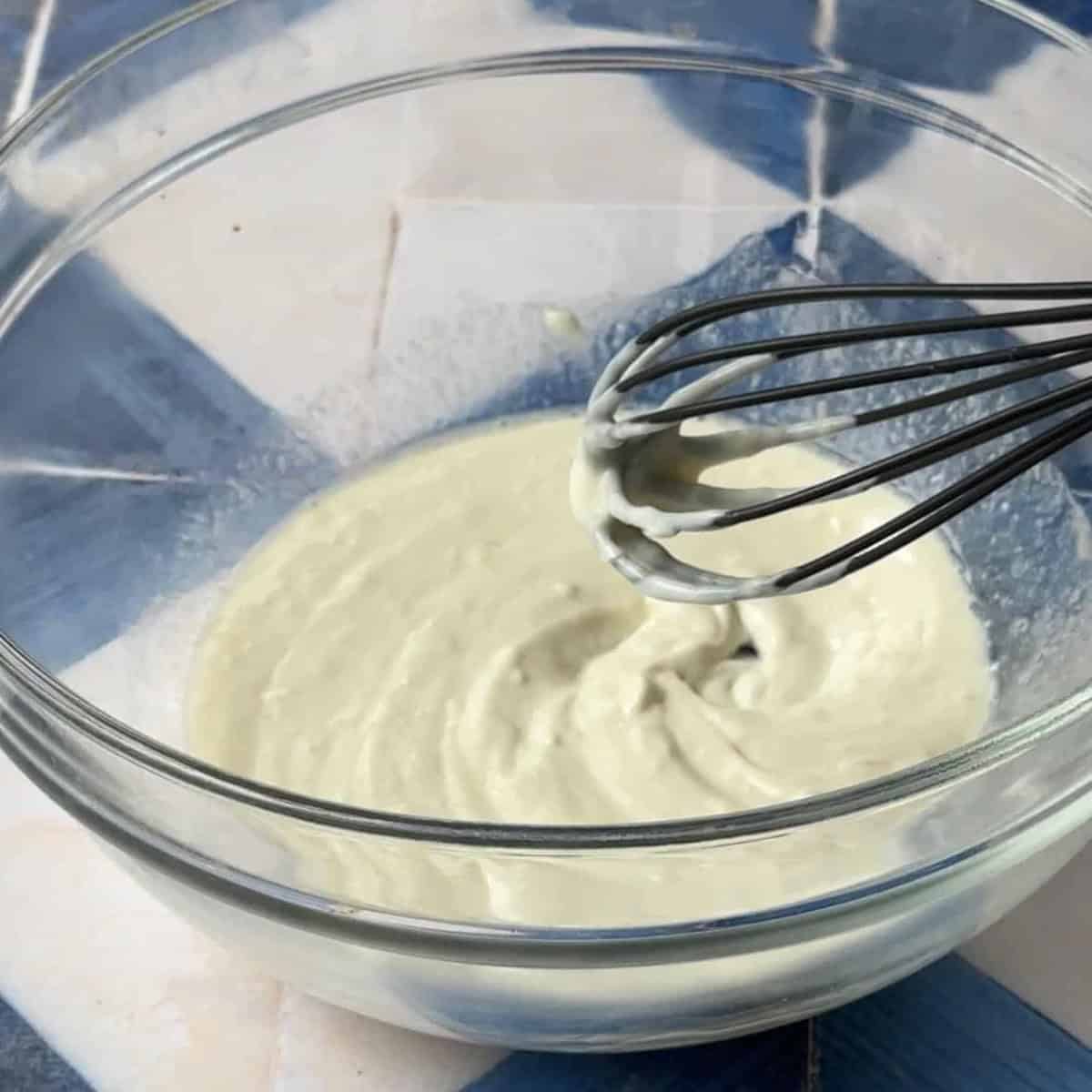 Smash Potato salad Dressing yogurt tahini dressing in a transparent glass bowl
