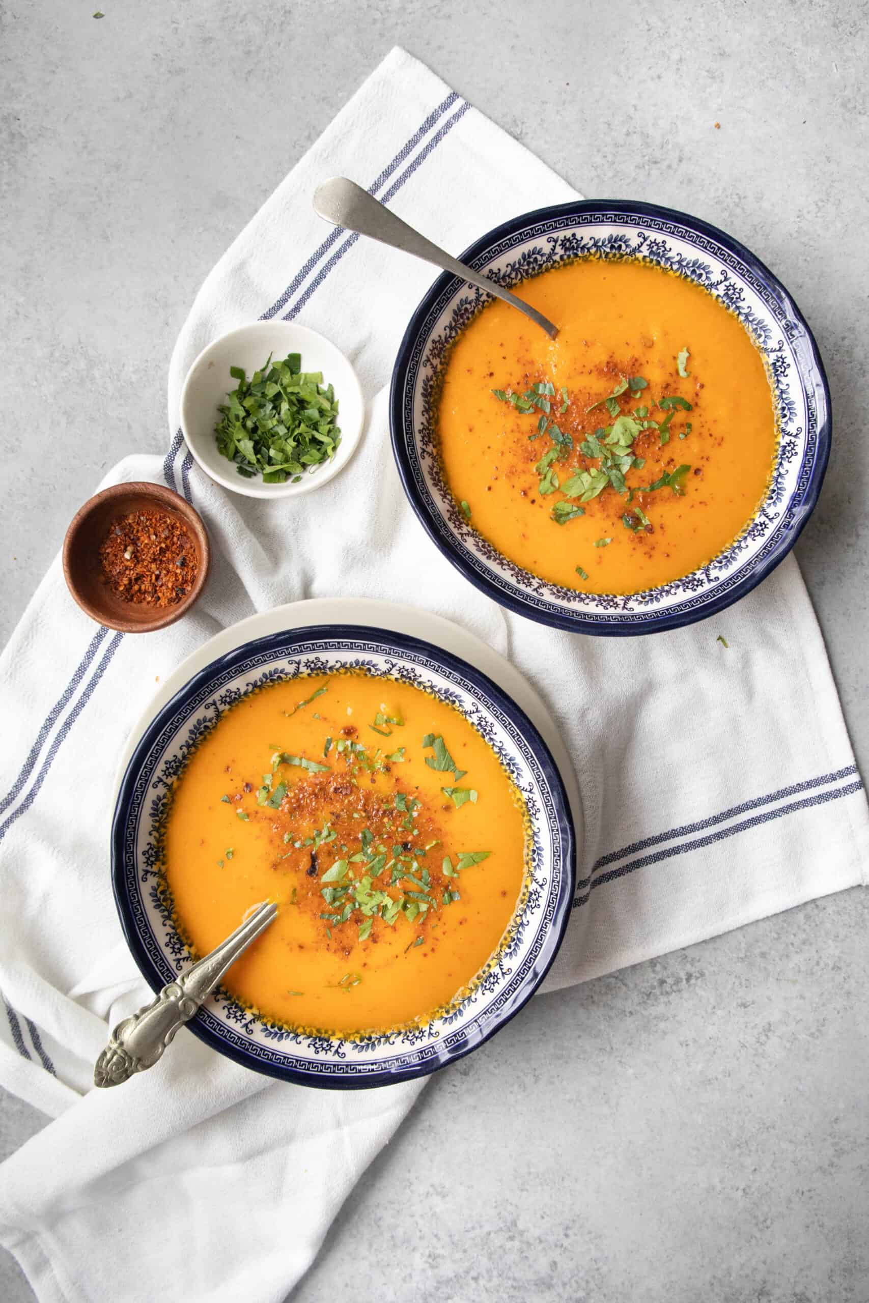 Roasted Carrot Soup two bowls of roasted carrot soup with garnish