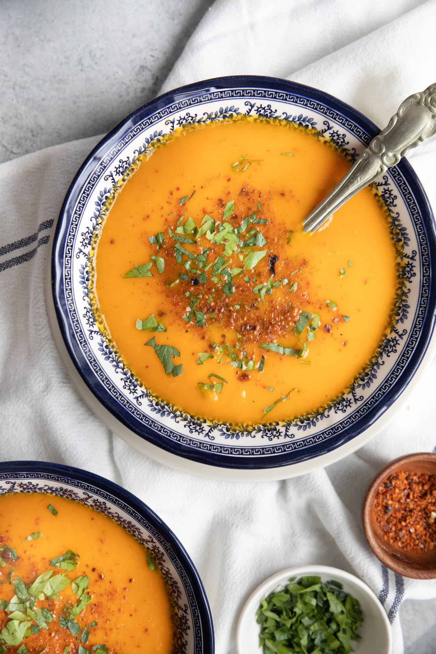 Best Roasted Carrot Soup two bowls of roasted carrot soup with garnish