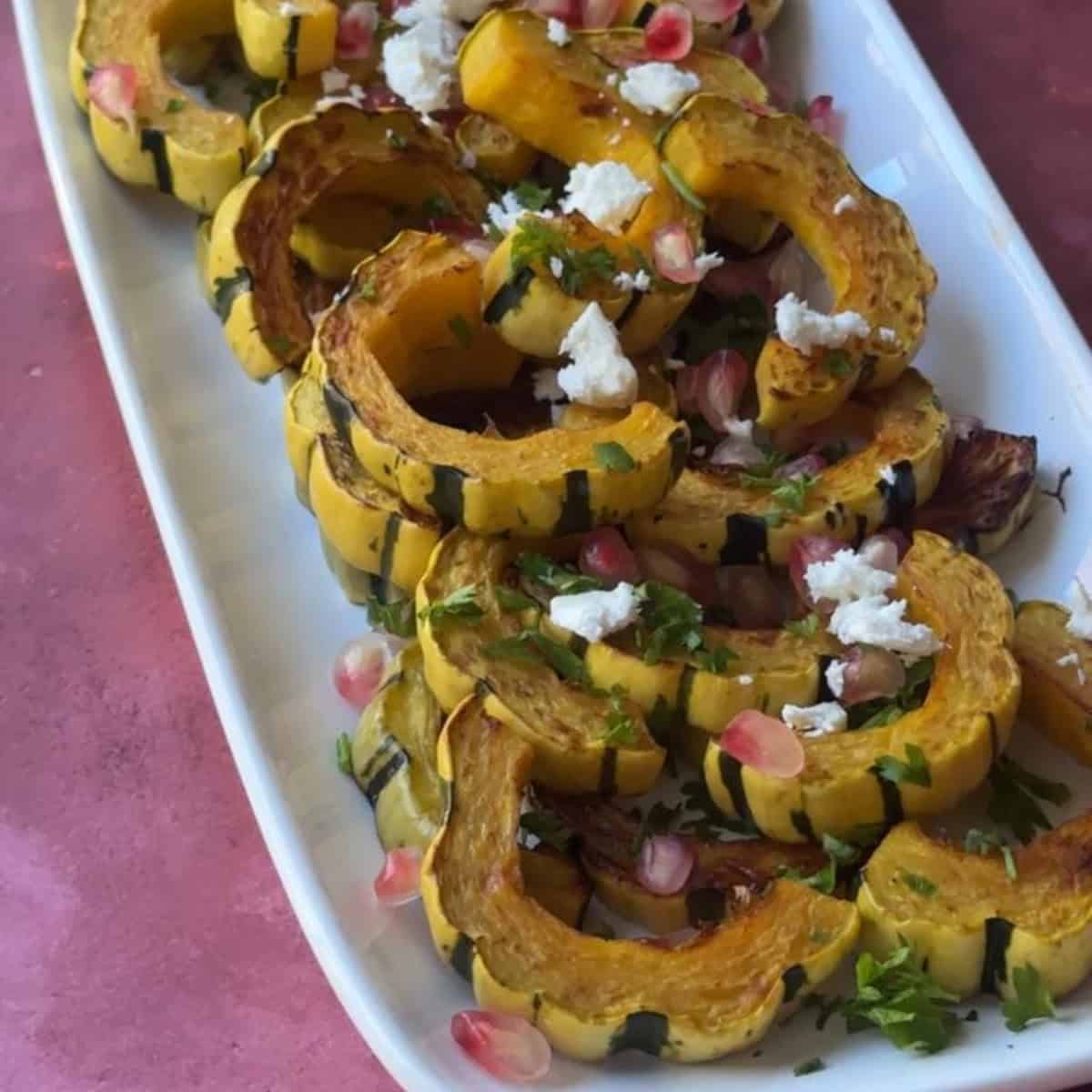 How to Make Roasted Delicata Squash delicata squash roasted and served on a white platter