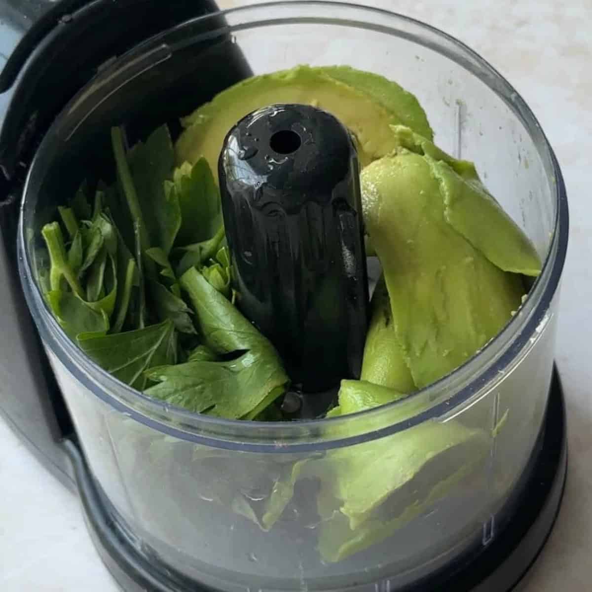 a food possessor containing avocado slices and parsley
