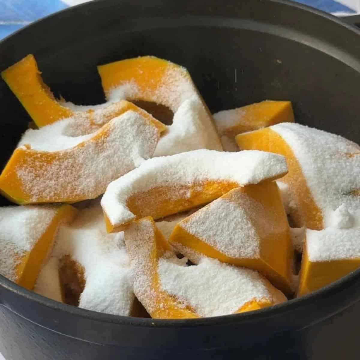 How to Make Kabak Tatlisi Raw pumpkin slices in a pot covered with sugar, ready to rest and release natural juices.