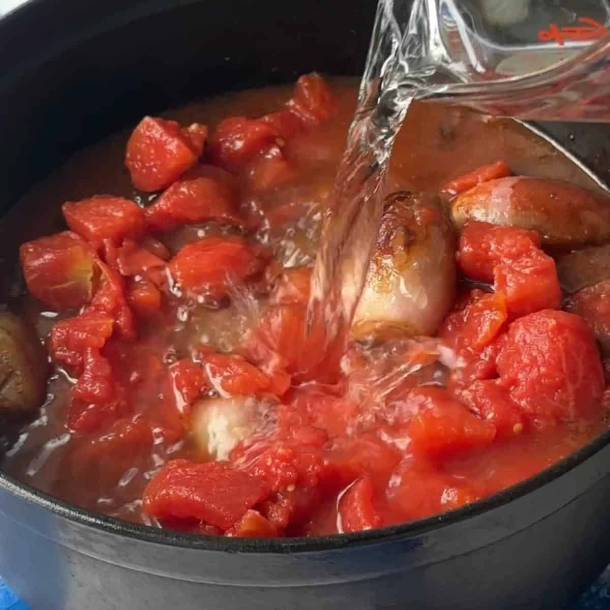 Add the tomatoes and water then cook until the beef is fully cooked.