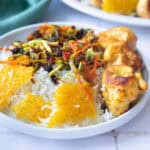 Persian jeweled rice on a plate with tahdig and chicken.