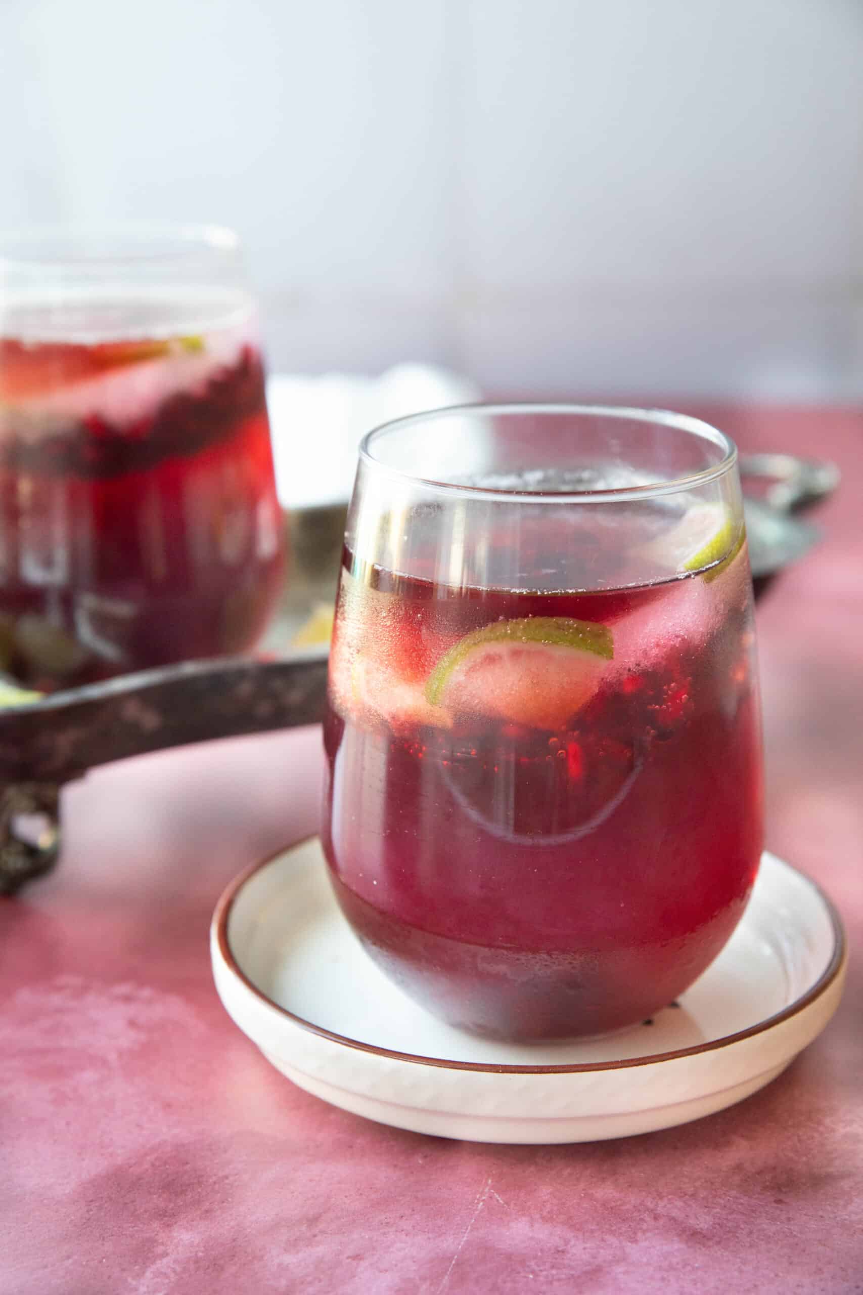 Pomegrante Mocktail Recipe pomegranate mocktail served in a transparent glass cup with the pomegranate arils and lime ice visible