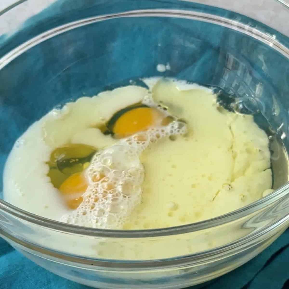 How-to-Make-Spinach-Feta-Borek A bowl containing 2 eggs, ½ cup of neutral oil, and 1 cup of milk, ready to be blended into a sauce for the borek.