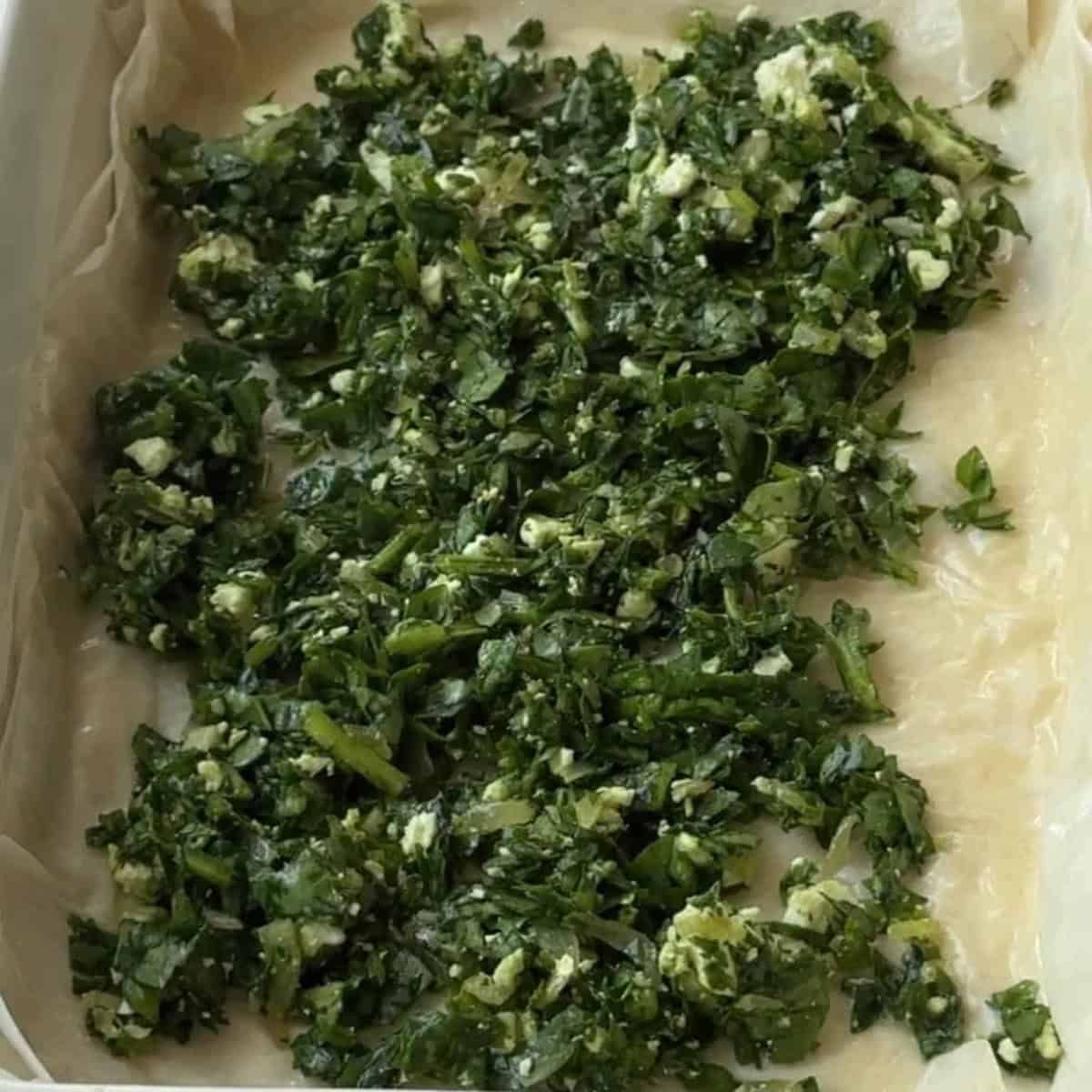 How to Make Spinach Feta Borek Half of the spinach mixture spread evenly over the layered phyllo dough in the baking pan.