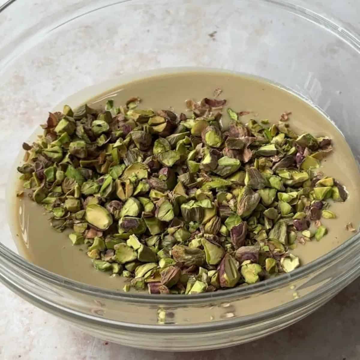 step by step tahini halva add tahini and pistachios to a bowl and mix