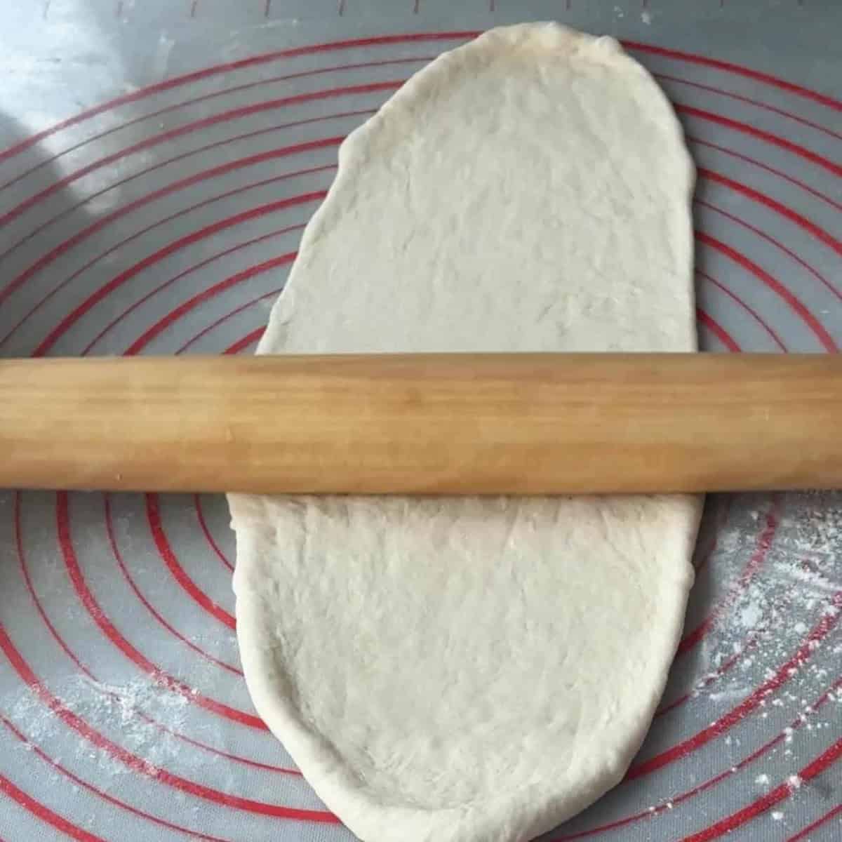 How To Make Turkish Pide Flatbread Roll dough into an oval shape on a floured surface.