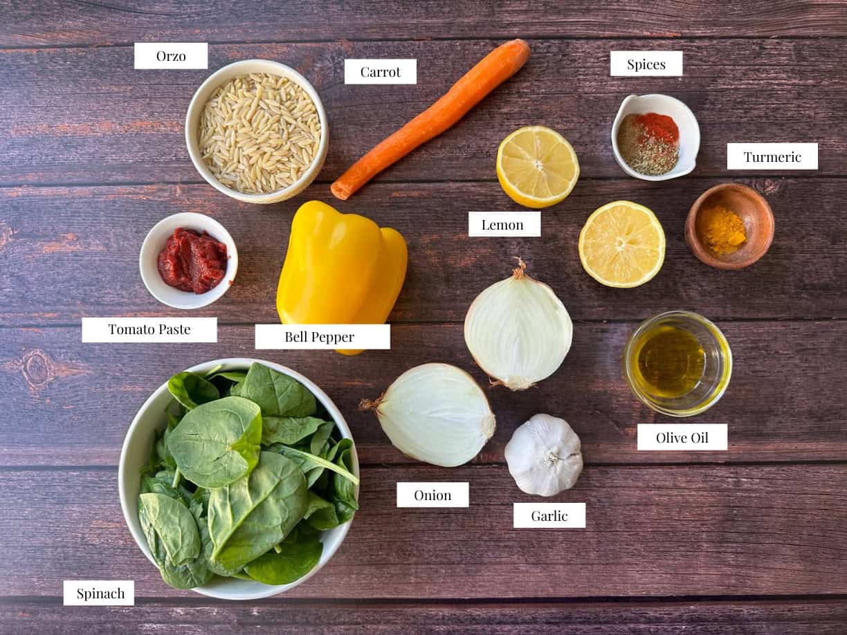 Ingredients for Mediterranean vegetable orzo soup, including olive oil, diced onion, minced garlic, chopped carrots, yellow bell pepper, tomato paste, cumin, oregano, turmeric, paprika, broth, orzo pasta, spinach, and lemon juice.