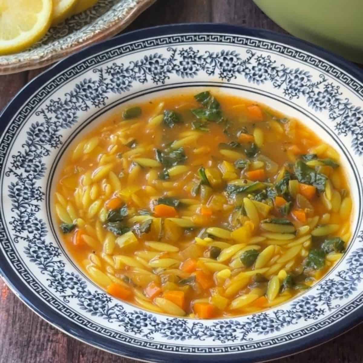 Bowl of vegetable orzo soup with vibrant vegetables and orzo pasta, drizzled with a little lemon juice for a zesty finish.