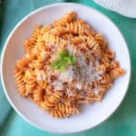 Close-up of rigatoni pasta with creamy red pepper sauce on a white dish